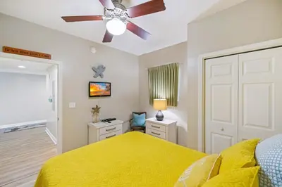 a bedroom with a yellow bed and a ceiling fan at Beachfront Stunning view 100 ft long swimming pool in Panama City Beach