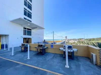 a balcony of a building with picnic tables and the beach at Beachfront Stunning view 100 ft long swimming pool in Panama City Beach