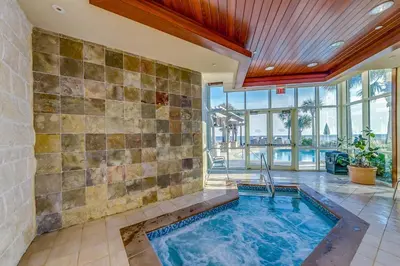 a swimming pool in a room with a tile wall at Aqua #2209 in Panama City Beach