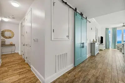 a hallway with white walls and a blue door at Aqua #2209 in Panama City Beach
