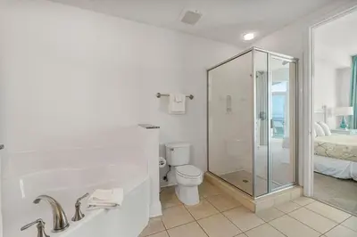 a white bathroom with a shower and a toilet at Aqua #2209 in Panama City Beach