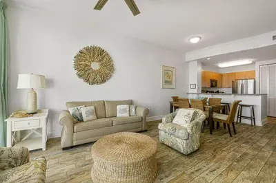 a living room with a couch and chairs and a table at Aqua #2209 in Panama City Beach