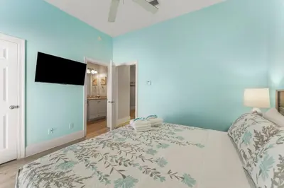 a bedroom with a large bed and a flat screen tv at Spectacular Gulf Views w/ PRIVATE POOL! Remarkable 3BR 35BA Bedding for 12! in Panama City Beach
