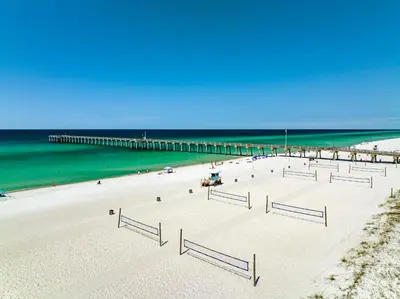 a white sandy beach with a pier in the water at Calypso #3-607 in Panama City Beach