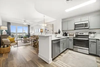 an open kitchen with stainless steel appliances and a living room at Calypso #3-607 in Panama City Beach