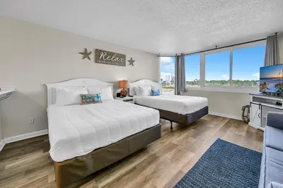 a hotel room with two beds and a balcony at Top of the Gulf 418 in Panama City Beach