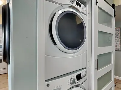 a washer and dryer in a white cabinet at Shores of Panama #1702 in Panama City Beach