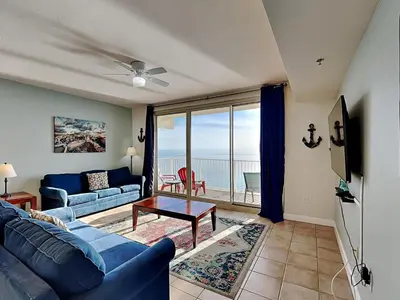 a living room with a blue couch and a table at Shores of Panama #1702 in Panama City Beach