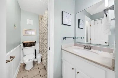 a white bathroom with a toilet and a sink at The Summit 1426 in Panama City Beach