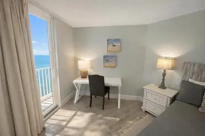 a bedroom with a desk and a bed and a window at Dunes of Panama E605 2BR 2BA BEACHFRONT condo in Panama City Beach