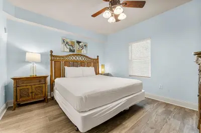 a bedroom with a white bed and a ceiling fan at Laketown Wharf #934 by Nautical Properties in Panama City Beach