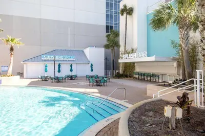 a swimming pool in front of a building with palm trees at Laketown Wharf #934 by Nautical Properties in Panama City Beach
