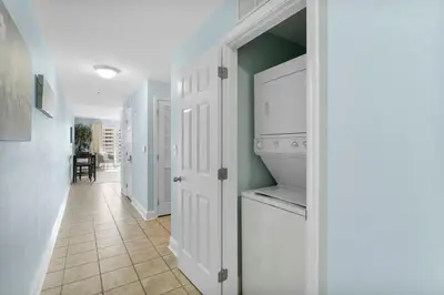 a kitchen with white cabinets and a tile floor at Laketown Wharf #519 by Nautical Properties in Panama City Beach