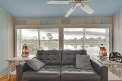 a leather couch in a living room with a ceiling fan at Panama City Beach Bay Point Condo Close to Golf! in Panama City Beach