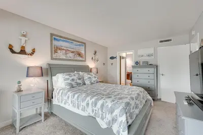 a bedroom with a bed and a dresser and a television at Panama City Beach Bay Point Condo Close to Golf! in Panama City Beach
