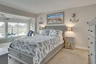 a bedroom with a bed and a desk and a window at Panama City Beach Bay Point Condo Close to Golf! in Panama City Beach