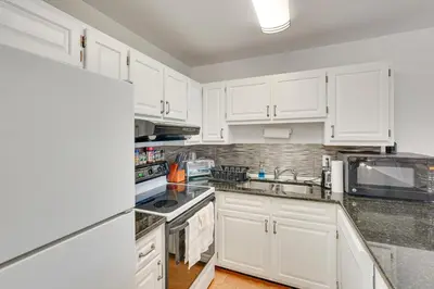 a white kitchen with white cabinets and a refrigerator at Panama City Beach Bay Point Condo Close to Golf! in Panama City Beach