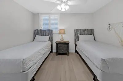 a bedroom with two beds and a night stand with a lamp at Sterling Beach #1206 in Panama City Beach