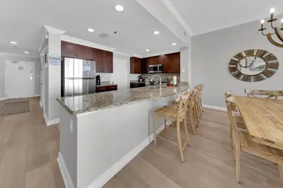 a kitchen and dining room with a counter and a table at Sterling Beach #406 in Panama City Beach