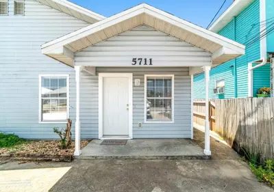 a blue house with a sign that reads at Tropical Gem/5 min beach walk in Panama City Beach