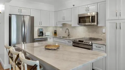 a kitchen with white cabinets and a large counter top at BeachCrest 302 Wave and Sea in Santa Rosa Beach