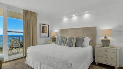 a white bedroom with a bed and a balcony at BeachCrest 302 Wave and Sea in Santa Rosa Beach