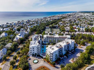 an aerial view of a white apartment building and the ocean at The Pointe on 30A #334 in Rosemary Beach