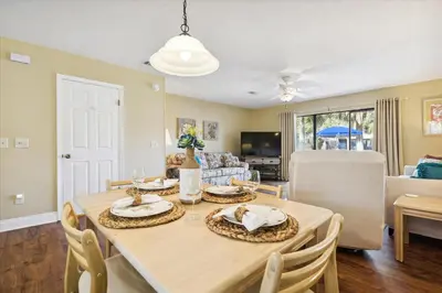 a dining room and living room with a table and chairs at Gulf Highlands 219 by Book That Condo in Panama City Beach