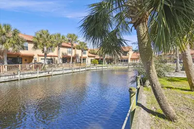 a river with palm trees and houses in the background at Gulf Highlands 219 by Book That Condo in Panama City Beach