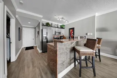 a kitchen with a counter and chairs in a room at Ocean Reef 704 in Panama City Beach