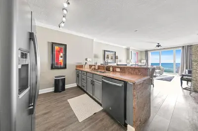 a large kitchen with a counter and a refrigerator at Ocean Reef 704 in Panama City Beach