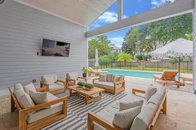 a patio with a couch and chairs and a pool at SOUTHERN SEABREEZE 5BR POOL & BEACH by Barclé in Rosemary Beach