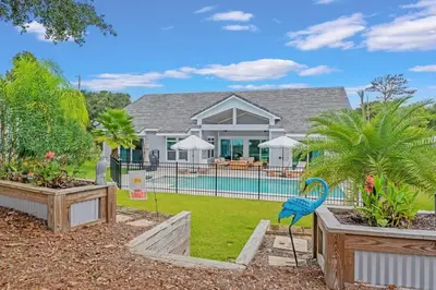 a house with a blue bird statue in the yard at SOUTHERN SEABREEZE 5BR POOL & BEACH by Barclé in Rosemary Beach