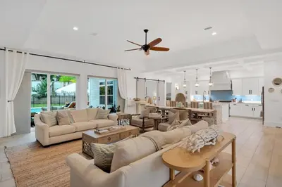 a living room with white furniture and a kitchen at SOUTHERN SEABREEZE 5BR POOL & BEACH by Barclé in Rosemary Beach