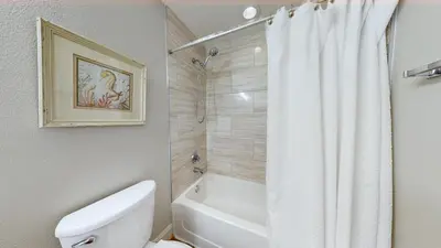 a bathroom with a white toilet and a shower at Tidewater 0401 in Panama City Beach