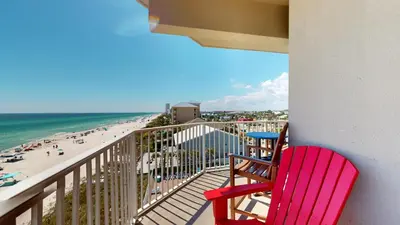 two red chairs sitting on a balcony overlooking the beach at Tidewater 0401 in Panama City Beach