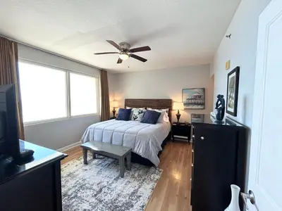 a bedroom with a bed and a ceiling fan at Amazing views! Great beachfront Panama City Condo in Panama City Beach