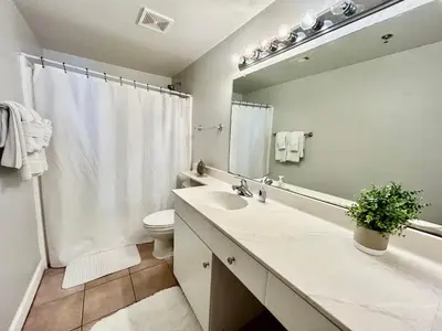 a bathroom with a sink and a toilet and a mirror at Amazing views! Great beachfront Panama City Condo in Panama City Beach