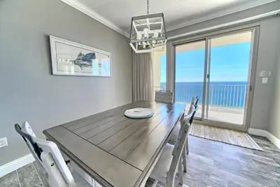 a dining room with a table and chairs and a large window at Oceanfront Paradise in Gated Community - 2304 condo in Panama City Beach