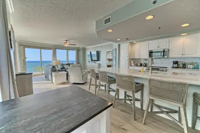 a kitchen and living room with a view of the ocean at Oceanfront Retreat with Panoramic Views - 0301 condo in Panama City Beach