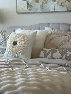 a bed with a flower pillow on top of it at Seaside Bliss in Gated Community - 1504 condo in Panama City Beach