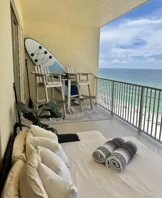 a bedroom with a bed and a balcony with a surfboard at Seaside Bliss in Gated Community - 1504 condo in Panama City Beach