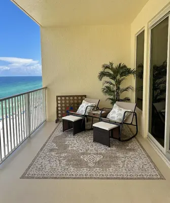 a living room with a couch and tables on a balcony at Seaside Bliss in Gated Community - 1504 condo in Panama City Beach