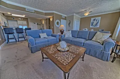 a living room with blue couches and a table at Oceanfront Paradise with Pool Access - 0606 condo in Panama City Beach