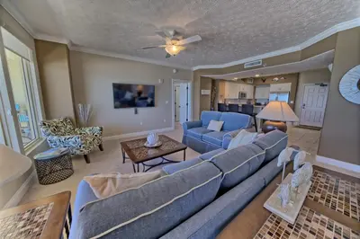 a living room with a blue couch and a table at Oceanfront Paradise with Pool Access - 0606 condo in Panama City Beach