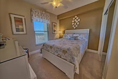a bedroom with a bed and a ceiling fan at Oceanfront Paradise with Pool Access - 0606 condo in Panama City Beach
