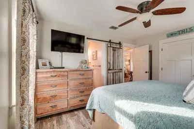 a bedroom with a bed and a dresser with a tv at Panama City Beach Home with Private Pool and Gas Grill in Panama City Beach