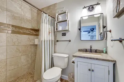 a bathroom with a toilet and a sink and a mirror at Panama City Beach Home with Private Pool and Gas Grill in Panama City Beach