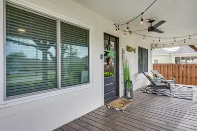 a house with a porch with a rocking chair on a deck at Panama City Beach Home with Private Pool and Gas Grill in Panama City Beach