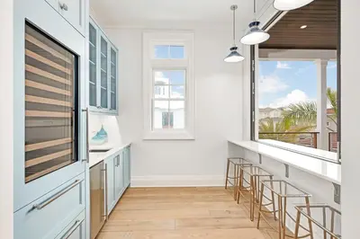 a kitchen with white walls and a large window at Seaclusion at Seagrove in Santa Rosa Beach